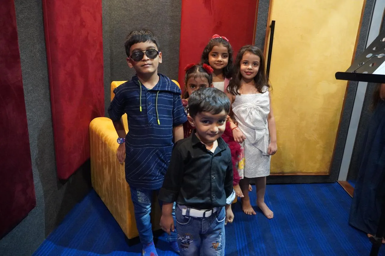 Young music academy students posing together inside the treated recording room