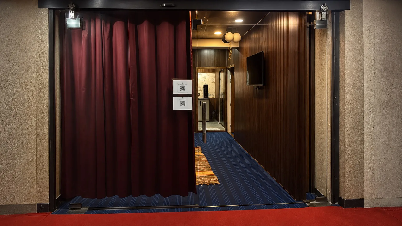 Enhanced wide view of the CloudStudio108 entrance curtain and blue-carpeted interior corridor