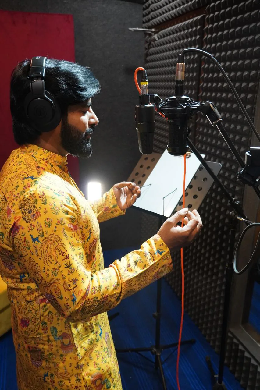 Side view of a vocalist performing inside the acoustically treated booth